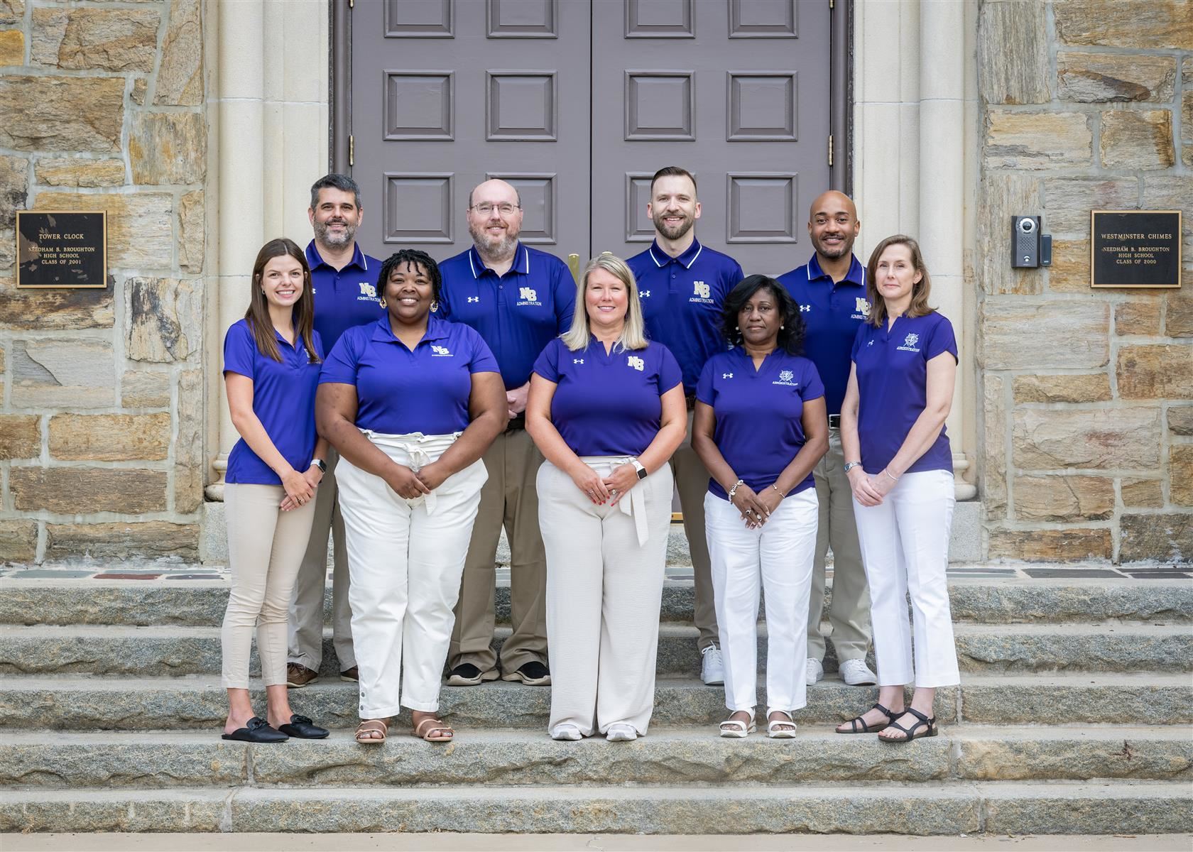 Broughton administrators standing in front of the front door, smiling